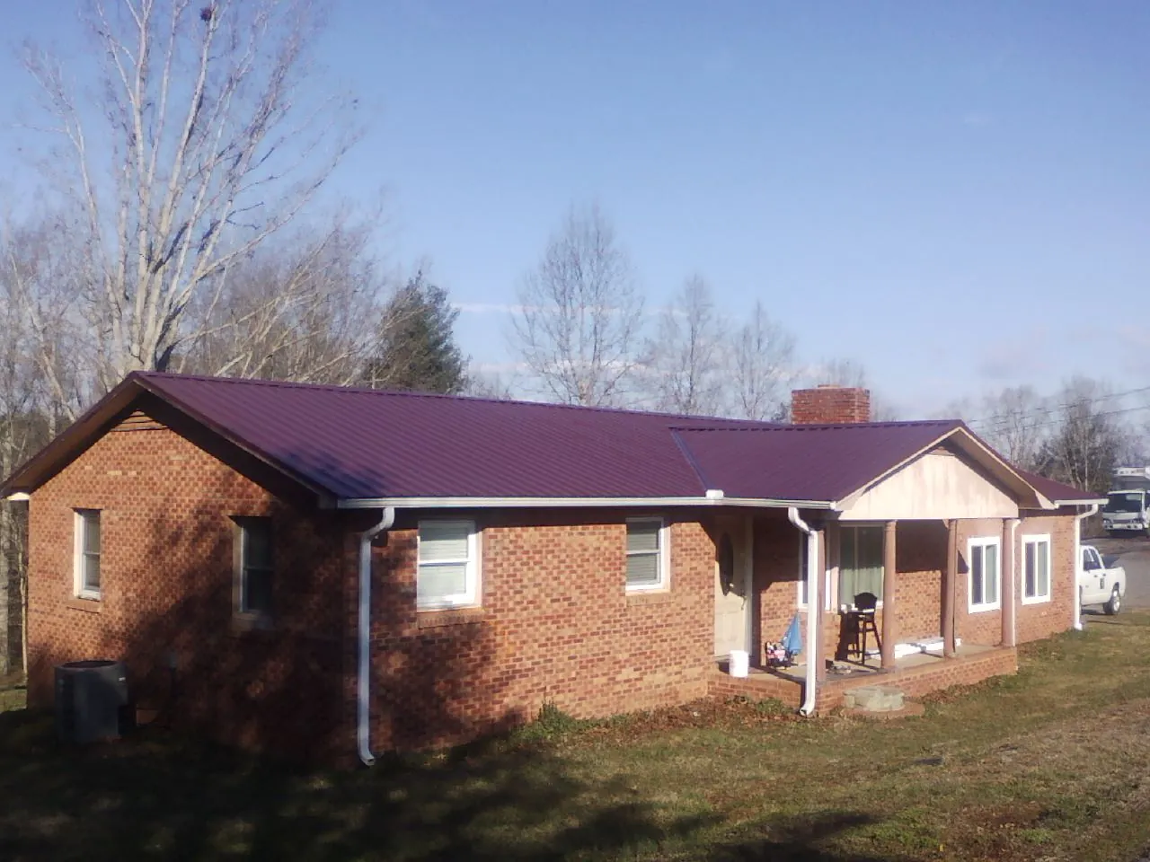 Burgundy metal roof on a brick ranch home with a new addition in Garysburg
