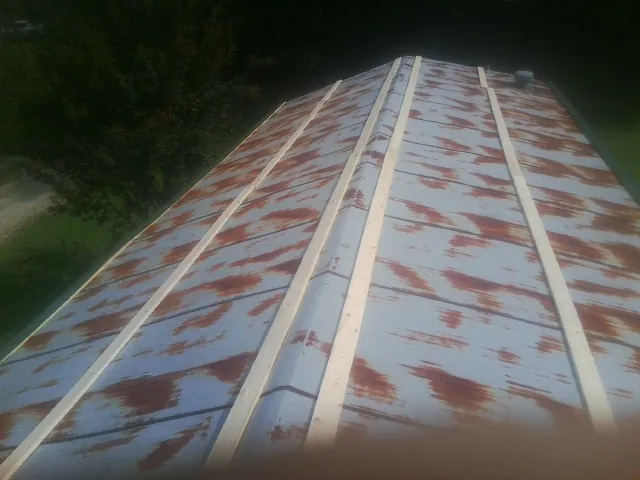 Rusted metal roof panels with new wood purlins before replacement — Storm Damage Roof Repair in Garysburg by Roofing Brothers