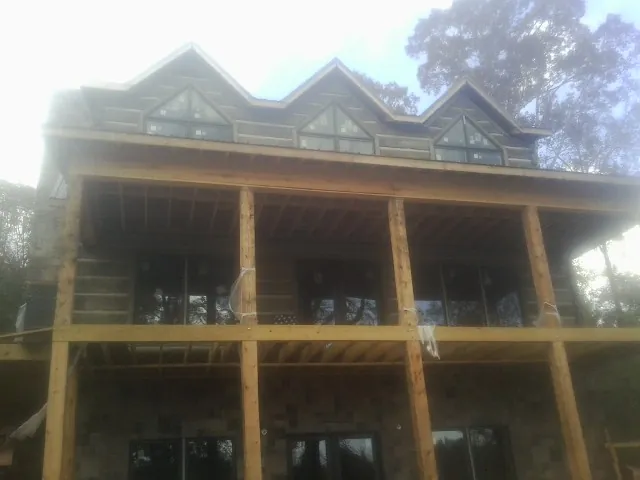 Dormers and porch framing on a large log home under construction — Roof Coating work by our crew in Garysburg