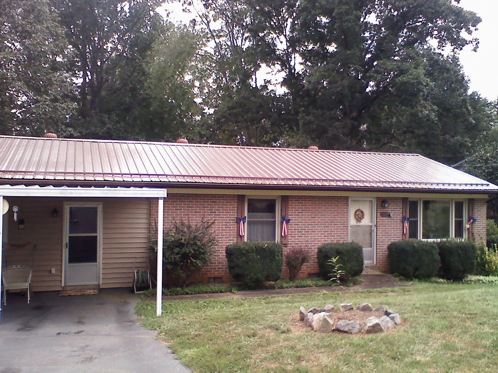 Bronze metal roof and carport on a brick ranch home — Roof Repair work by our crew in Garysburg
